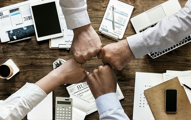 Hands from a business put together in support for teamwork.